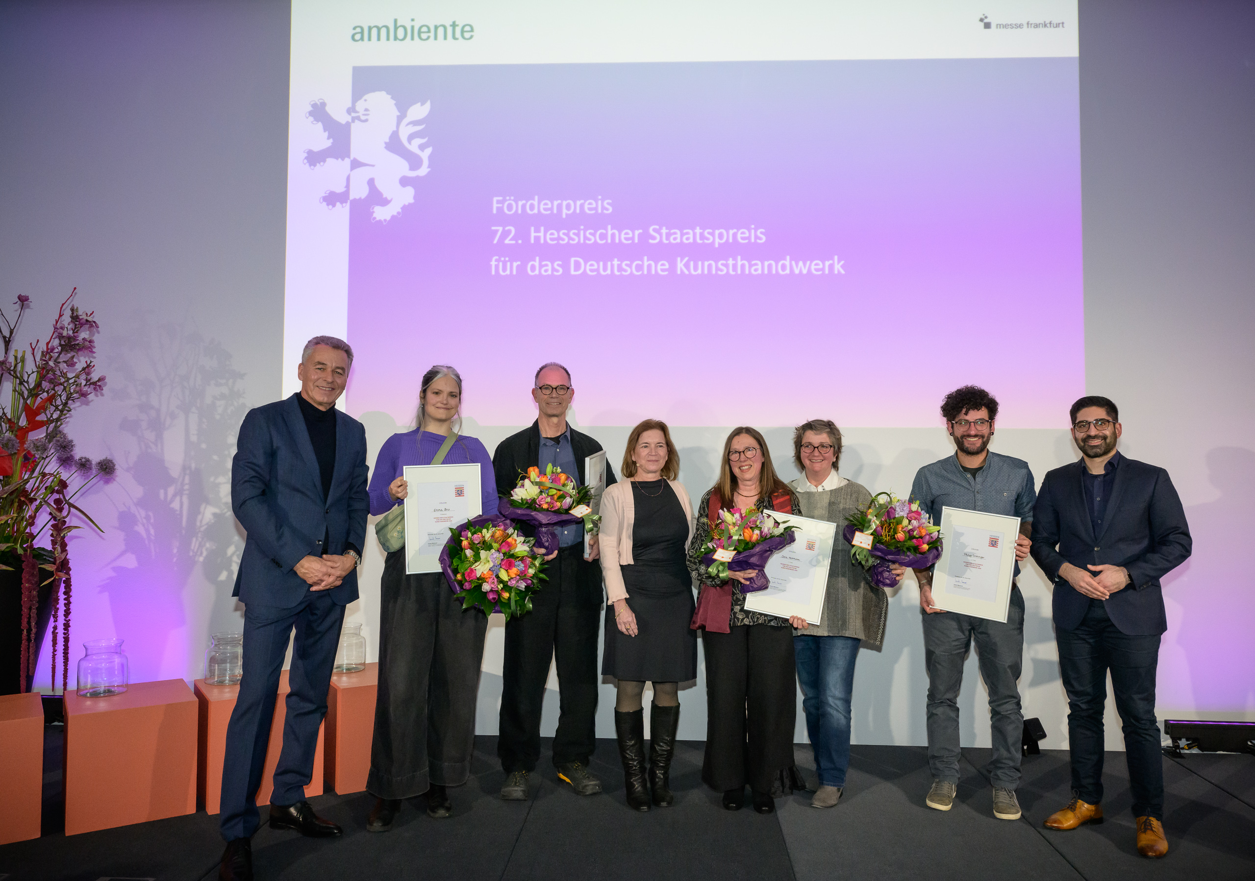 Die Verleihung des Hessischen Staatspreises für das Deutsche Kunsthandwerk im Rahmen der Ambiente 2024 (v.l.n.r.): Detlef Braun, Geschäftsführer der Messe Frankfurt, Emma Brix (Förderpreis), Christoph Leuner (1. Platz), Marianne Kassamba, Bundesverband Kunsthandwerk, Dora Herrmann und Alexandra Wiechert (3. Platz), Philipp Gröninger (2. Platz), Kaweh Mansoori, Staatsminister im Hessischen Ministerium für Wirtschaft, Engergie, Verkehr, Wohnen und ländlichen Raum sowie Moderator Stefan Suchaneck. Foto: Messe Frankfurt / Pietro Sutera.